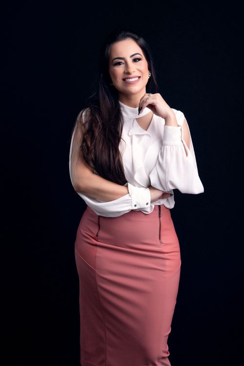 Free Elegant woman in professional attire smiling confidently against a black background. Stock Photo