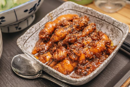 Delicious spicy chicken dish served in a ceramic bowl, garnished with pepper.