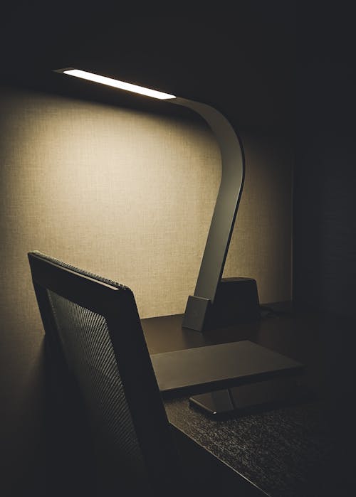 Black and Gray Desk Lamp on Brown Wooden Table