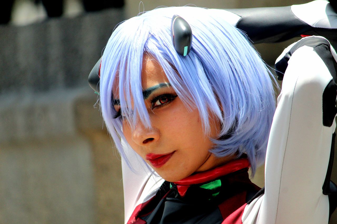 portrait of a woman in anime cosplay with blue wig and costume showcas