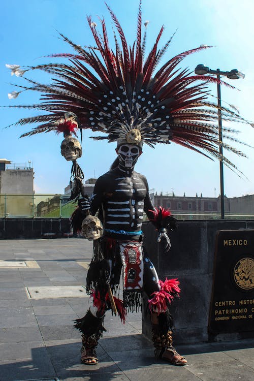 Woman in Black and Red Dress Standing Near Black Statue