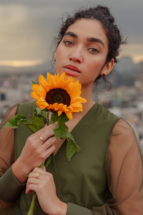 Free Woman in Green Tank Top Holding Sunflower Stock Photo