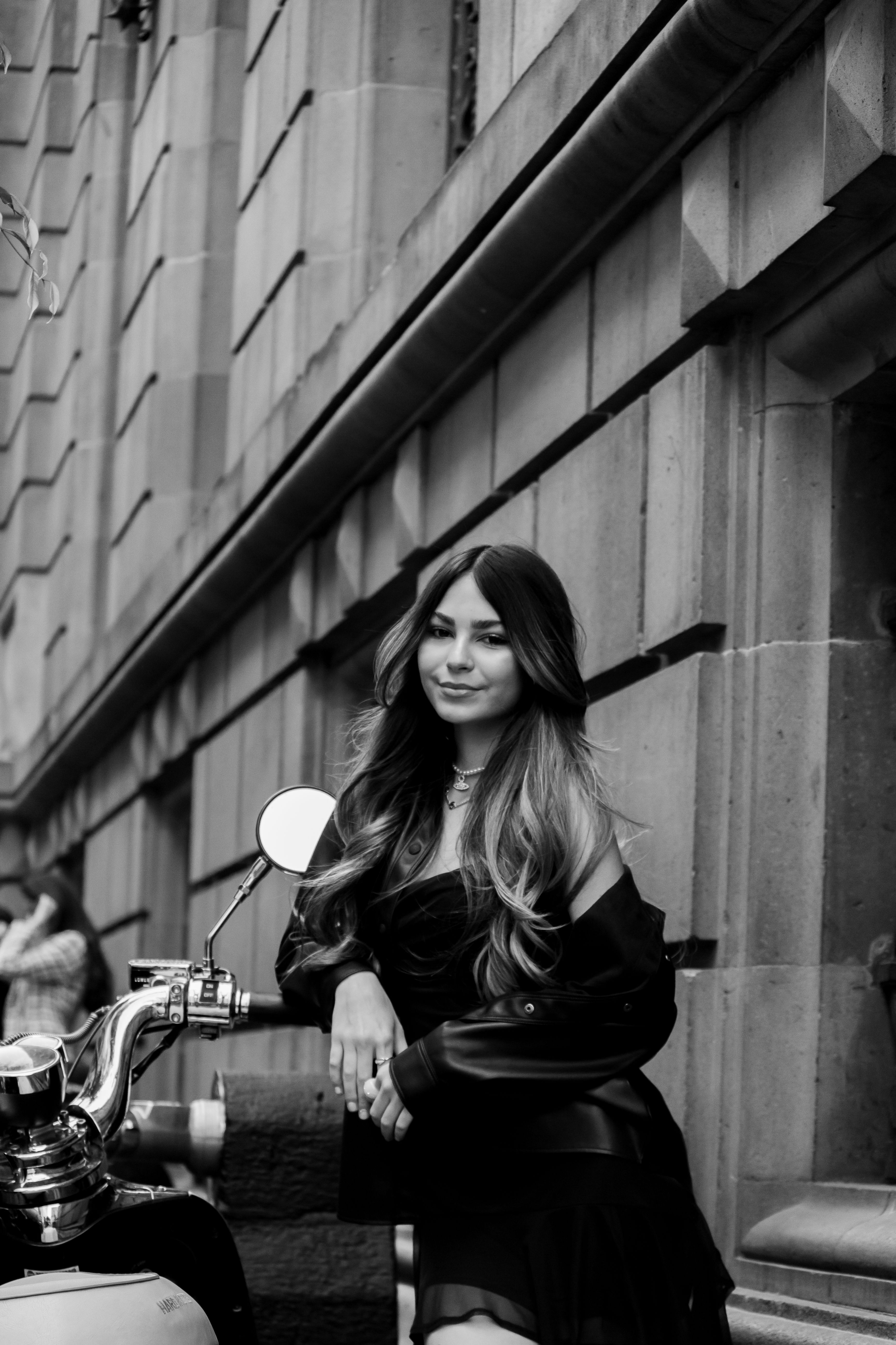 Grayscale Photo of a Woman Standing Beside a Motorcycle · Free Stock Photo