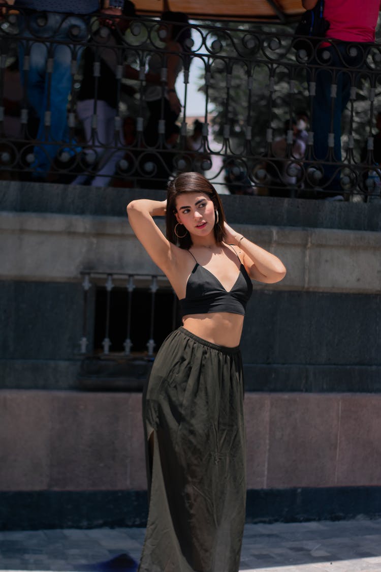 A Woman In Black Brassiere And  Gray Skirt Swaying Her Hips