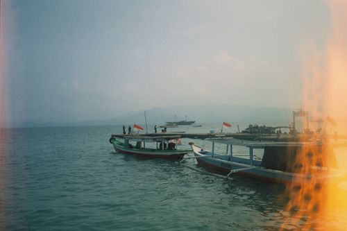 Free Fishing boats with Indonesian flags at Bandar Lampung harbor on a cloudy day. Stock Photo