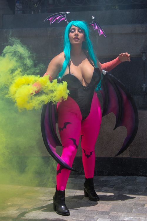 Free A colorful cosplayer stands boldly, surrounded by vibrant smoke, showcasing elaborate costume details and dynamic posing. Stock Photo