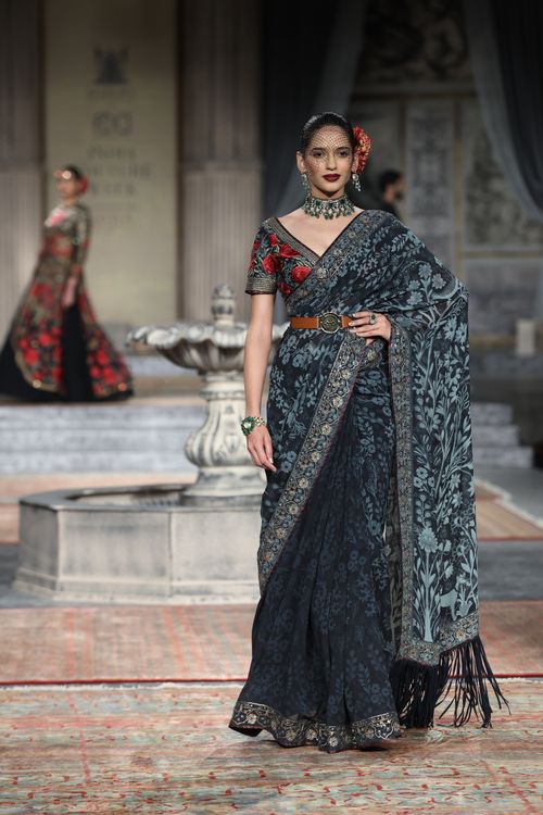 Free Fashion model in designer saree showcases elegant style on runway at fashion show. Stock Photo