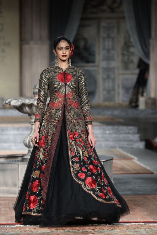 Free Fashion model gracefully walks the runway in an ornate, floral embroidered ball gown during a fashion show. Stock Photo