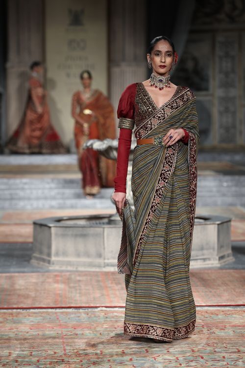 Free Indian model in traditional attire gracefully walks the runway at a fashion show. Stock Photo