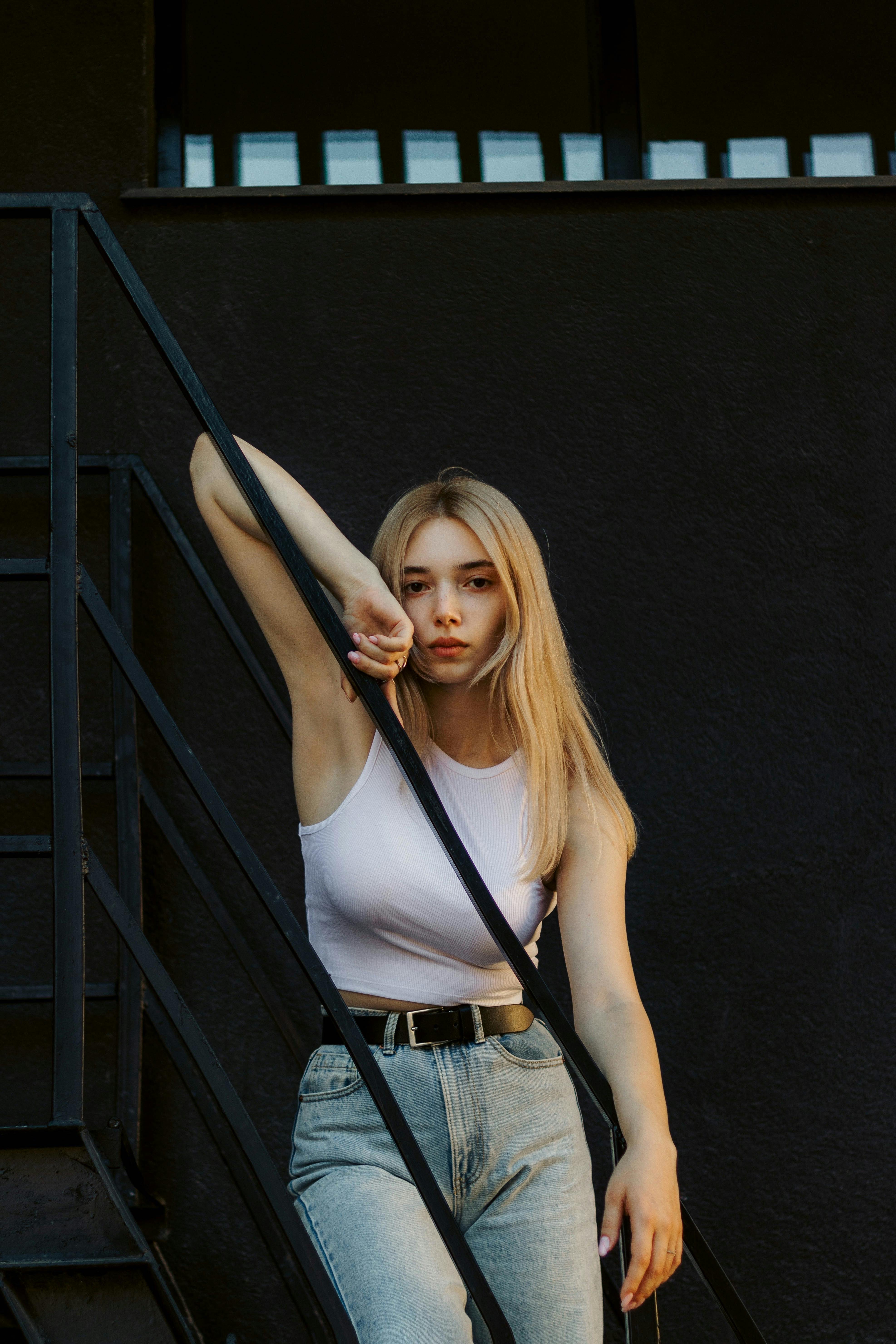 blond woman posing by handrail