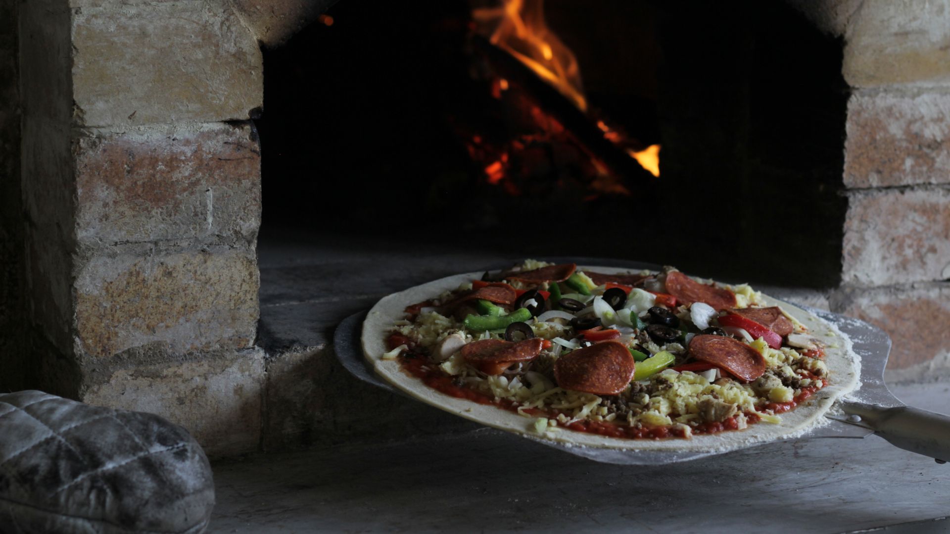Authentic pizza baking in a traditional stone oven in Indonesia.