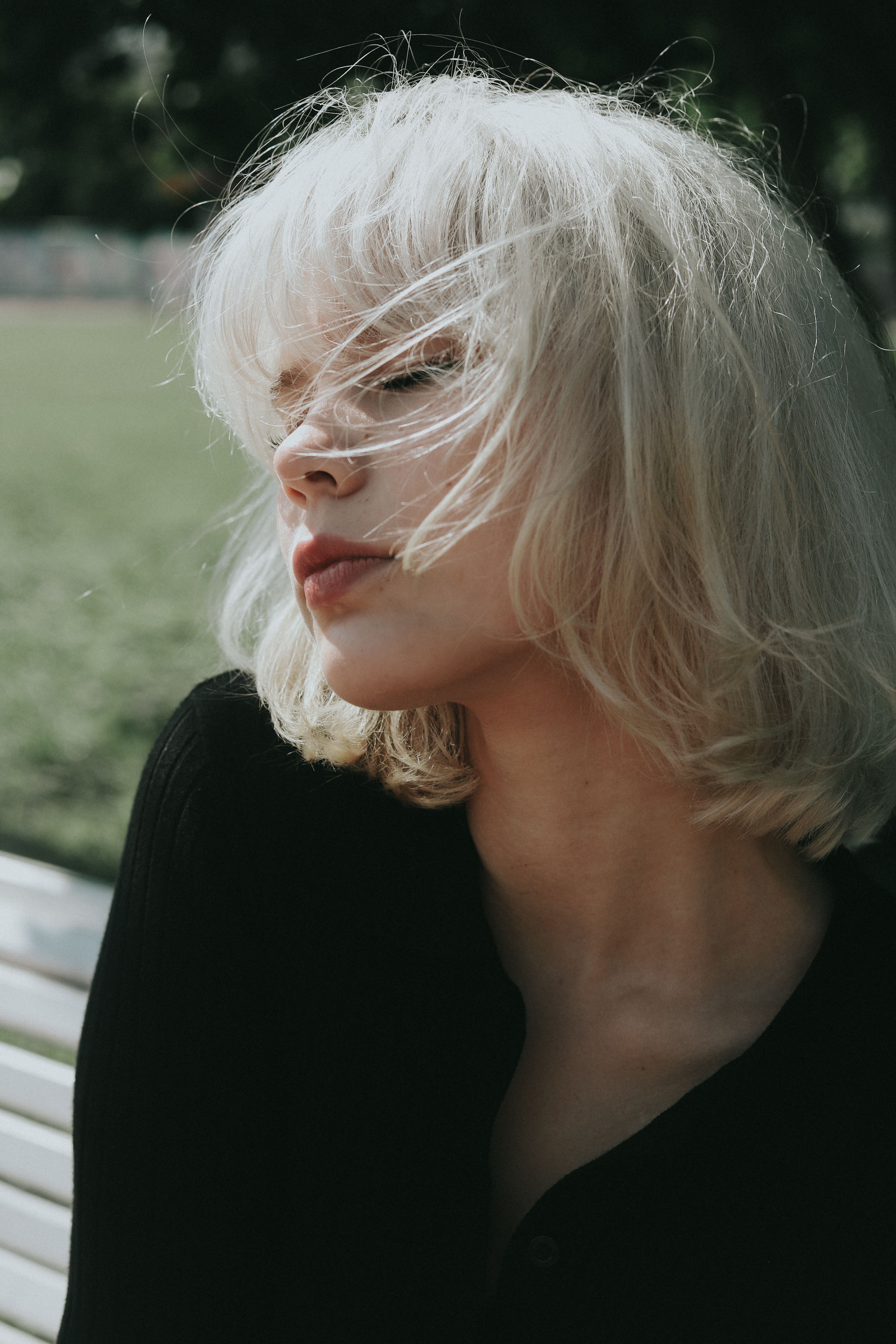 Portrait of a blonde woman with eyes closed, enjoying the outdoors.