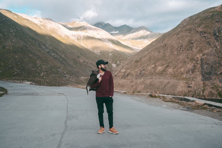 A Man Standing On The Concrete Road