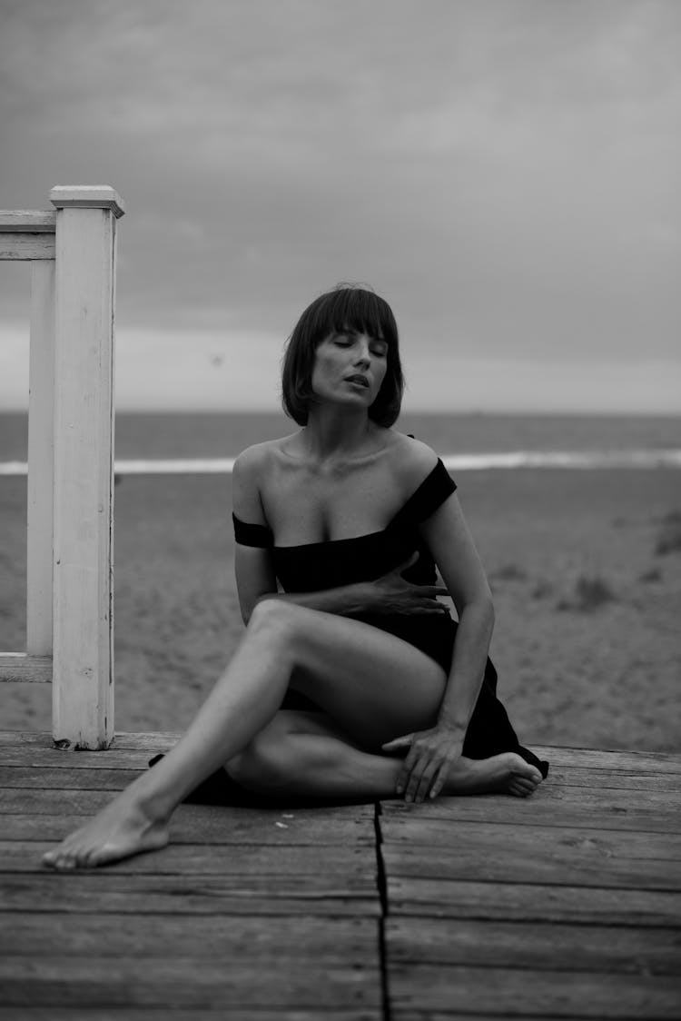 A Woman Sitting On A Pier