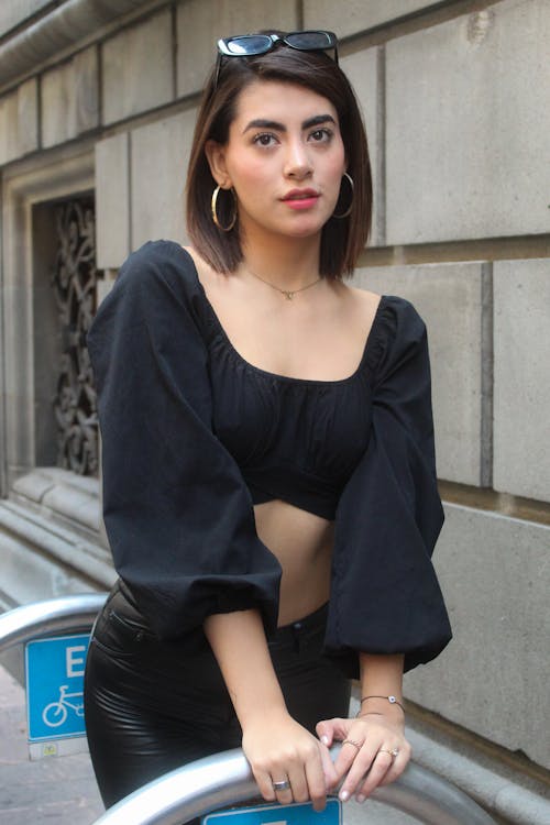 Beautiful Young Woman in Black Long Sleeve Crop Top Posing on Bike Rack Stand