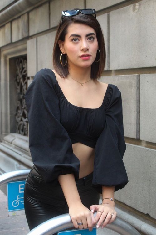 Free Stylish woman in a trendy crop top poses confidently by a bike rack. Stock Photo