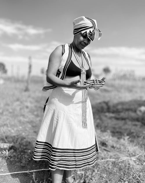A Woman in Traditional Clothes Standing on Field