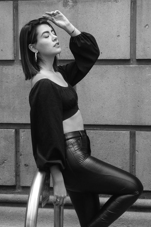 Free Fashionable woman in monochrome outfit posing against urban backdrop, showcasing modern street style. Stock Photo
