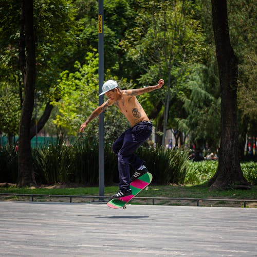 Shirtless Man Skateboarding on Skate Ramp