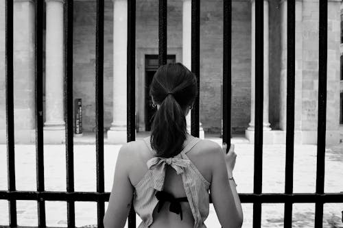 Free Woman Holding on a Gate Stock Photo