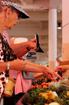 Elderly women selecting fresh produce at an indoor market, browsing fresh vegetables.
