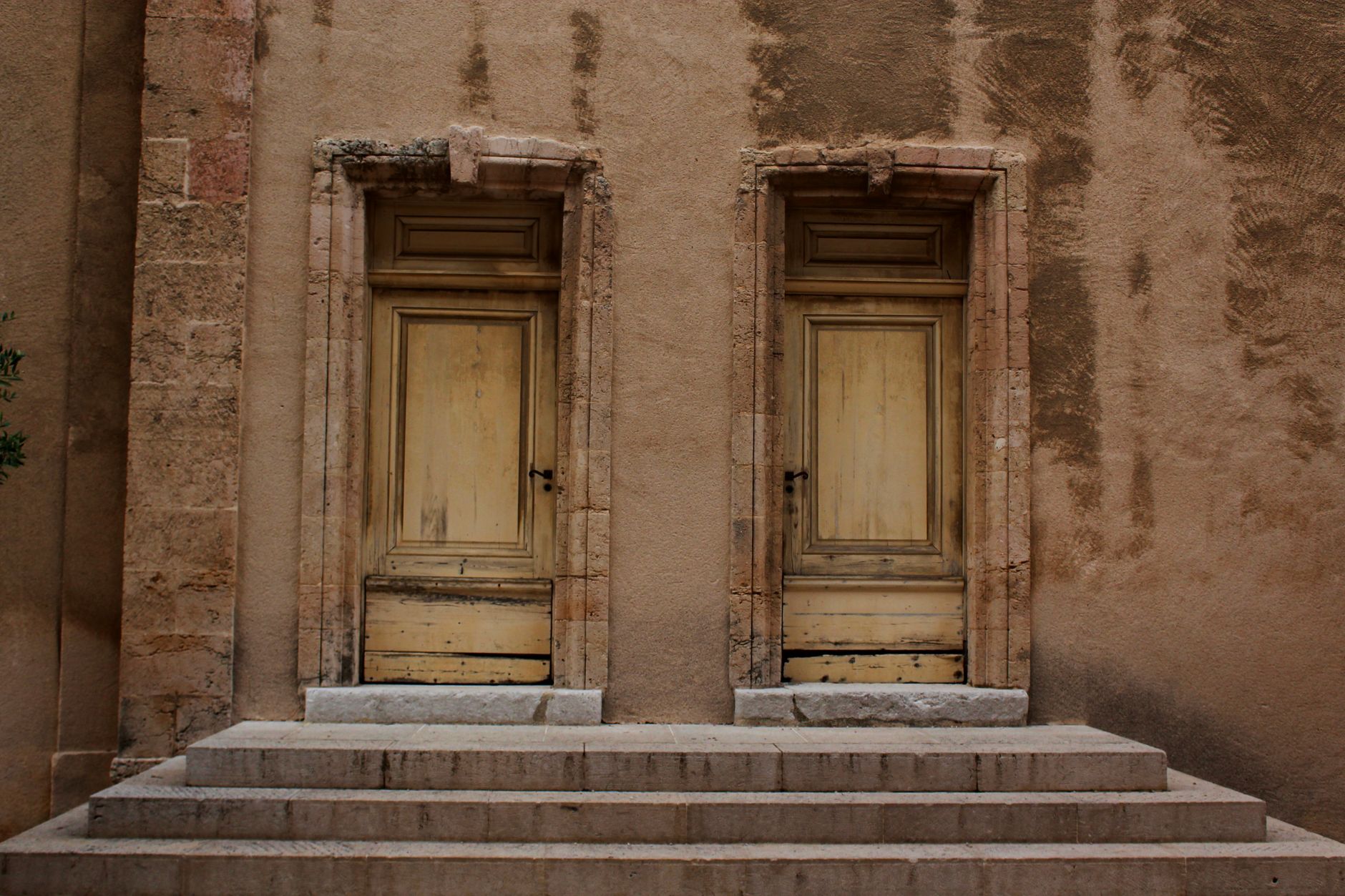 Twin wooden doors on a rustic stone building showcasing classic architecture.