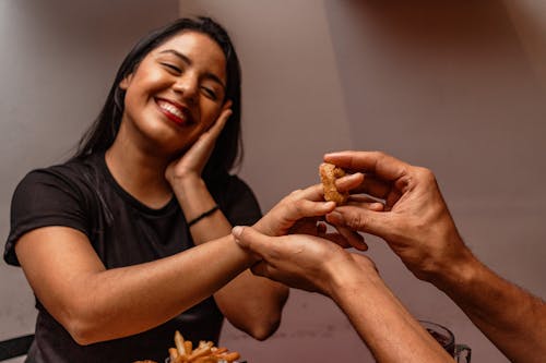 A Person Putting an Onion Ring on a Woman's Finger