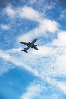 A commercial airplane flying high in the clear blue sky with fluffy clouds in Turkey.