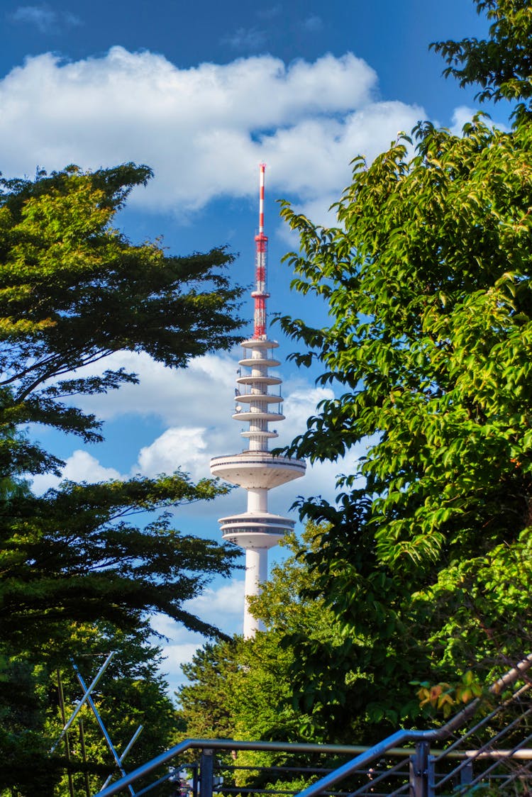 White Tower Near Green Trees Under Blue Sky