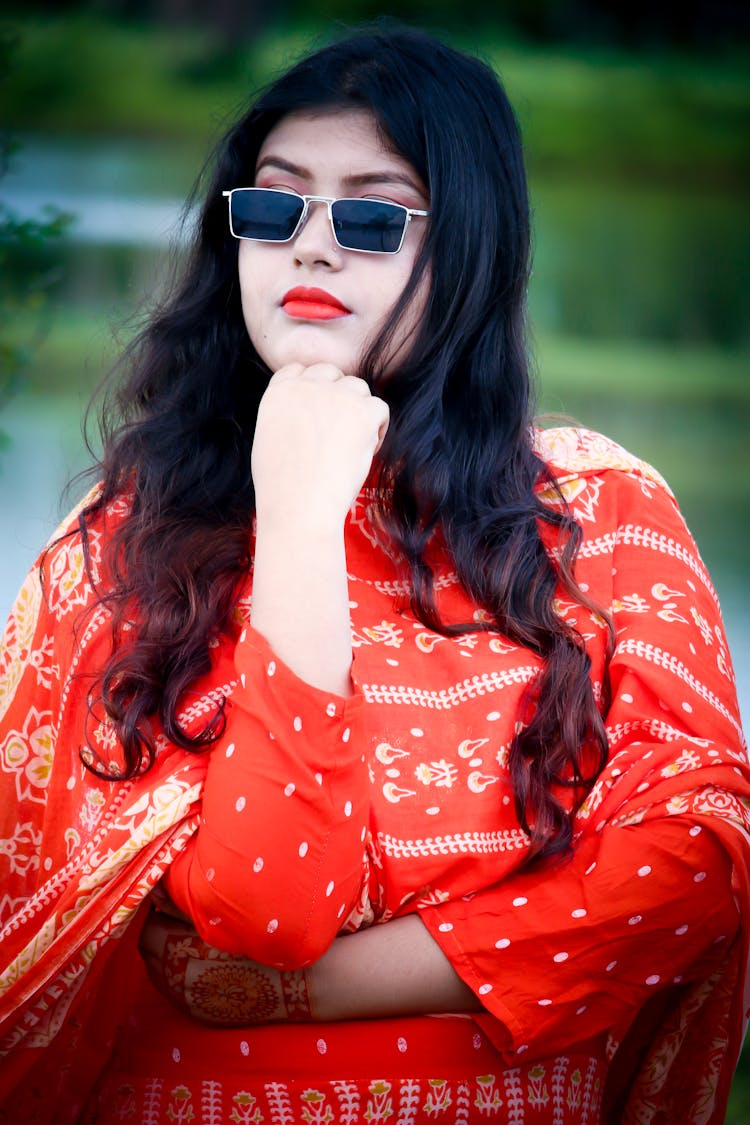 Young Woman Wearing Red Dress Holding A Hand Under The Chin