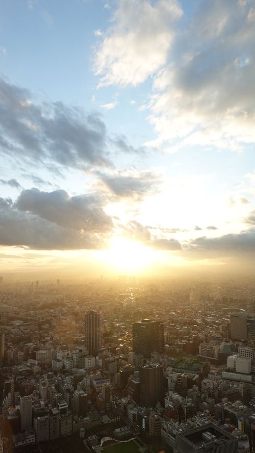 Free Stunning aerial shot of a cityscape at sunrise with a golden hour glow over buildings. Stock Photo