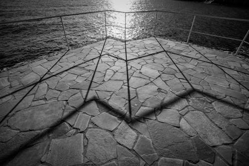 Pier with Stone Pavement and Sun Reflecting in Water