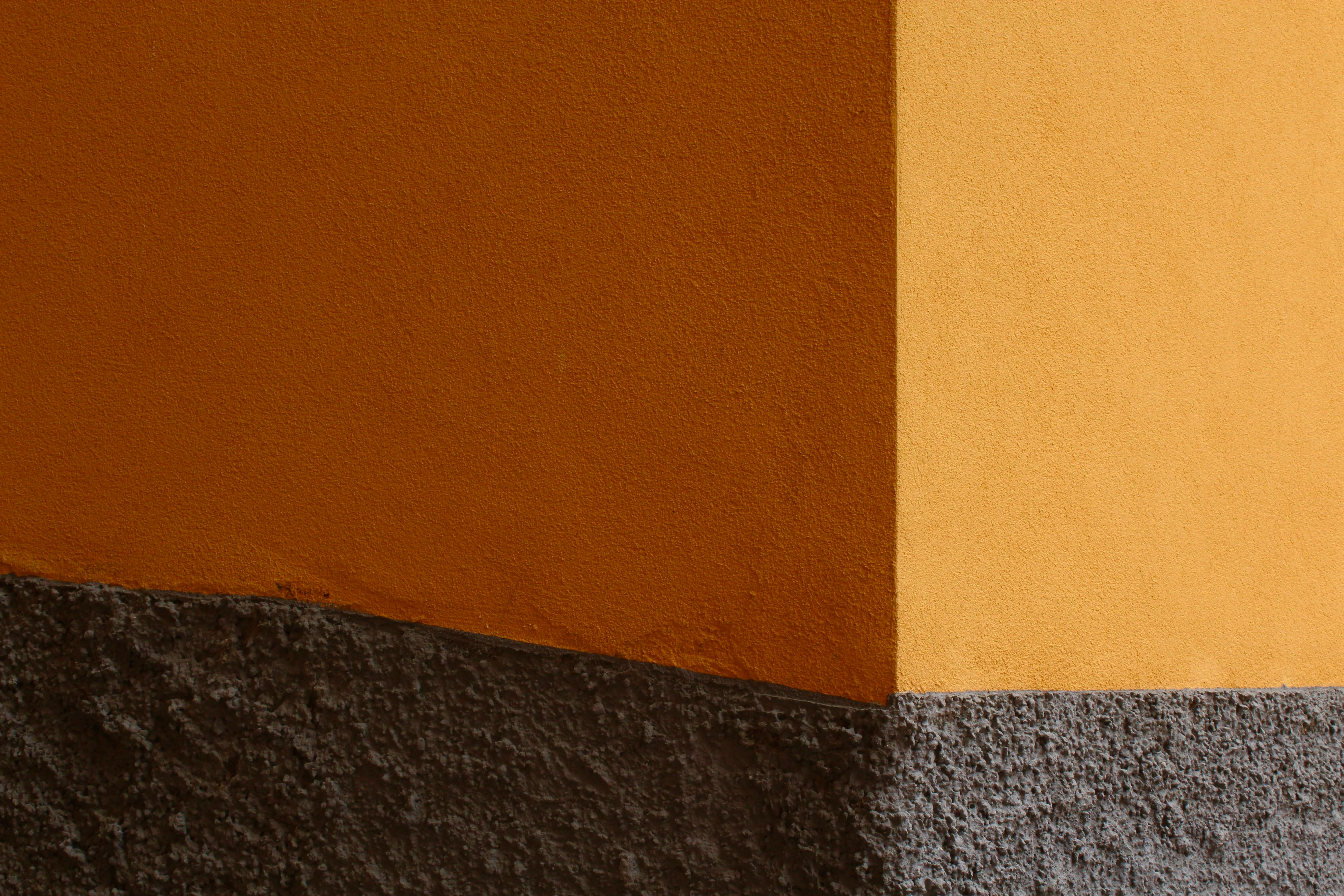 Free Detailed view of an orange wall corner with texture and shadow contrast. Stock Photo