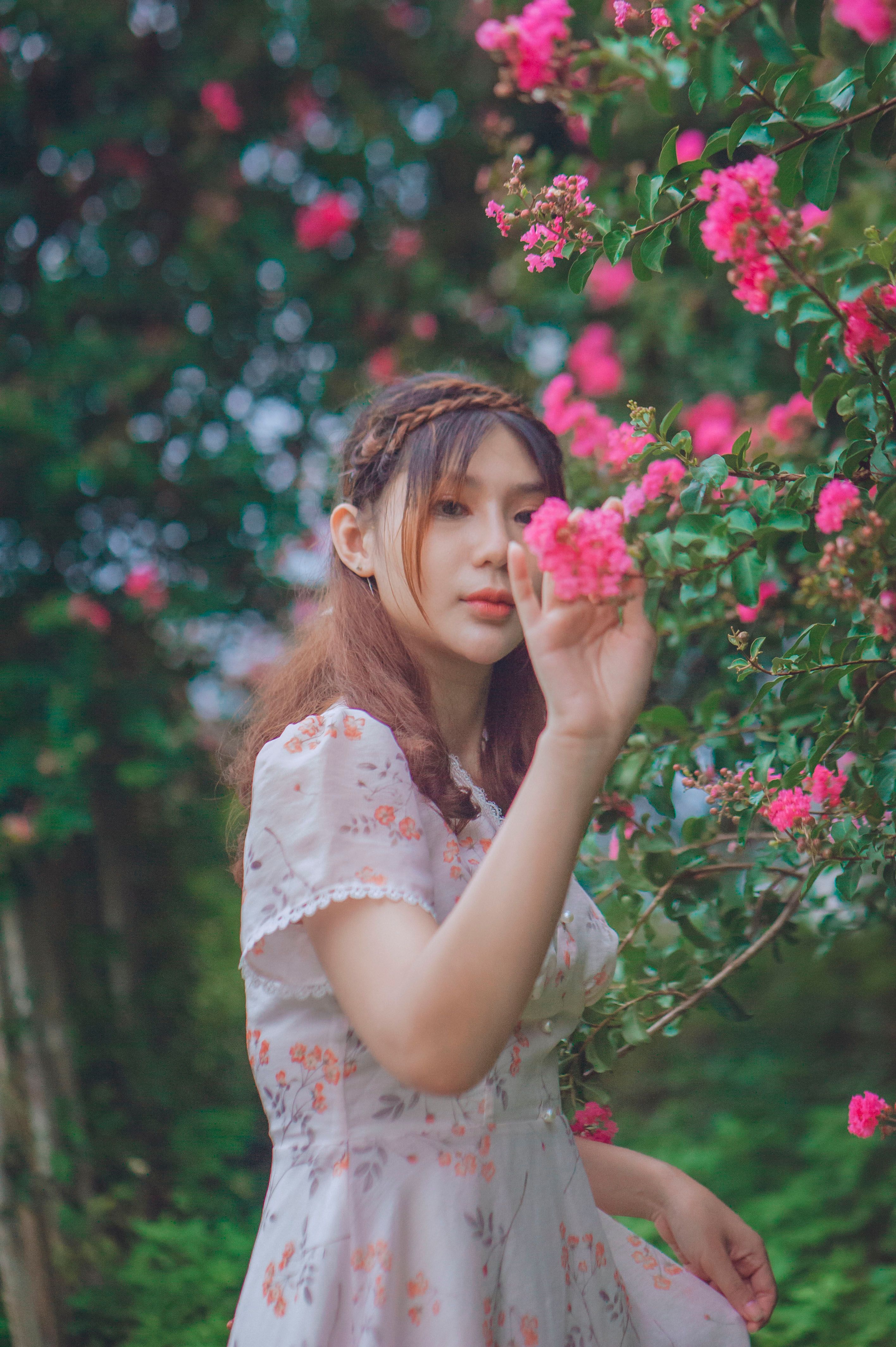A Woman in Pink Dress Holding Pink Flowers · Free Stock Photo
