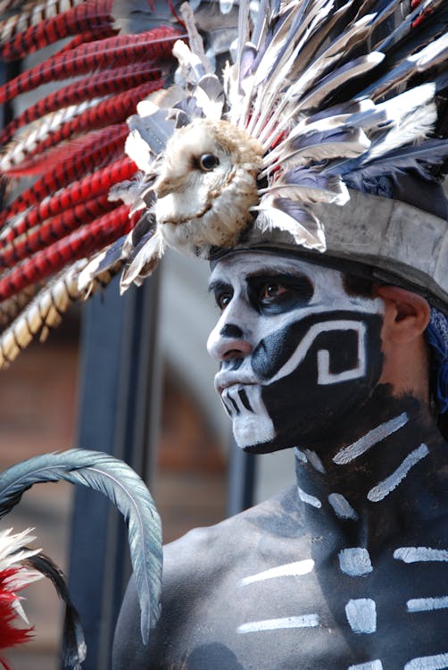 Man with Black and White Body Paint Wearing Feather Headdress
