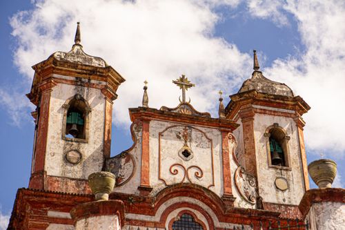Free Photograph of a historic Baroque church facade with twin towers in Ouro Preto, Brazil under a clear blue sky. Stock Photo