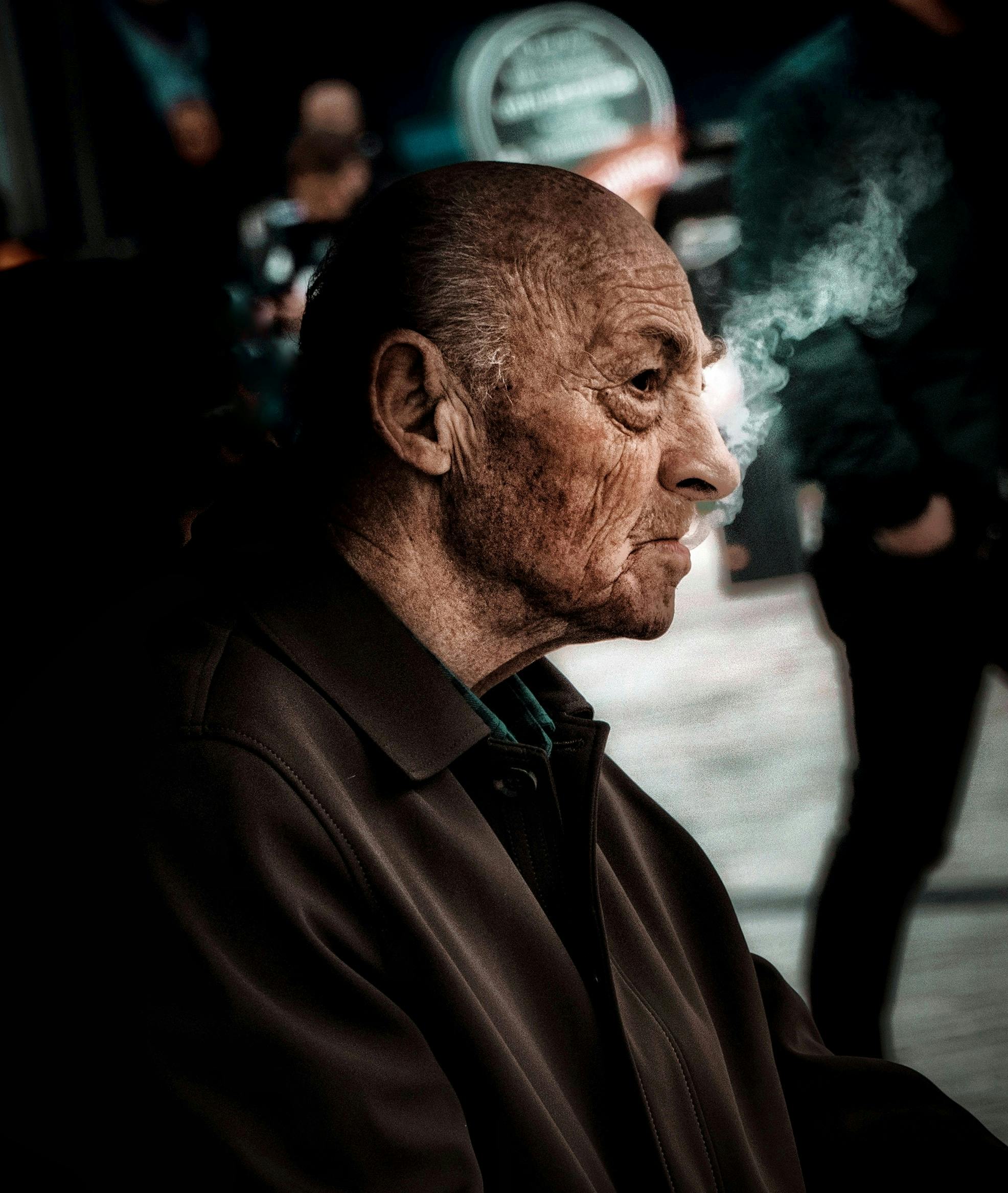 close up photo of a senior man in brown coat