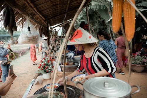 Free Vibrant scene of a woman serving food at a lively outdoor market stall, capturing cultural authenticity. Stock Photo
