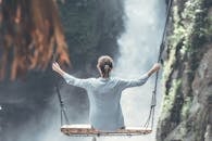 Woman Riding Big Swing in Front of Waterfalls