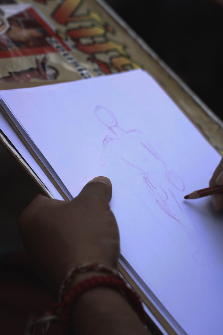 Person Sketching On A Bond Paper