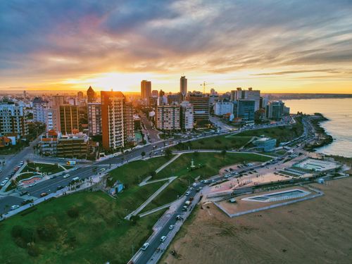 Free Stunning aerial view of a coastal city skyline at sunset with vibrant skies and urban landscape. Stock Photo