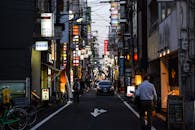 黄昏时分，街景捕捉了日本城市的灯光、标志、城市生活与交通