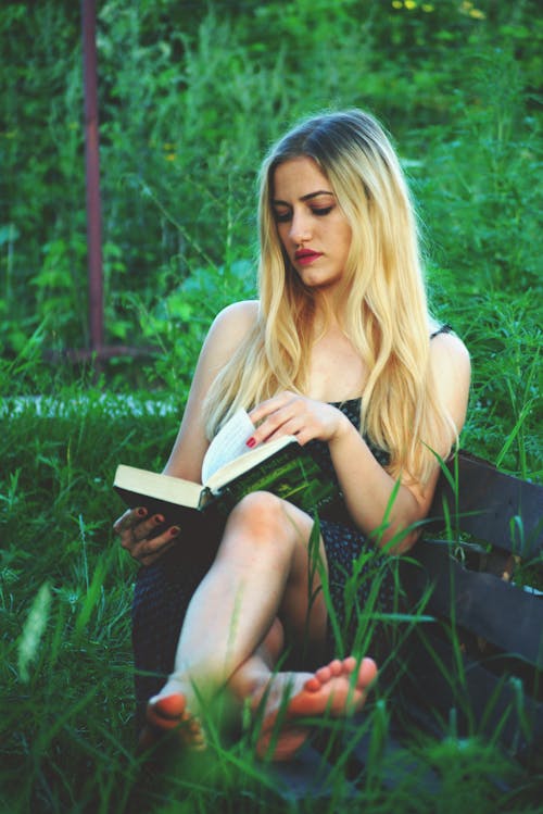 Free Woman Sitting While Reading Book Stock Photo