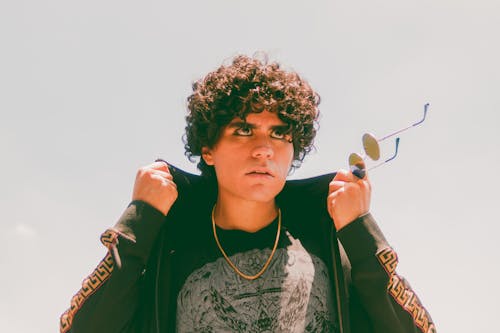 A Man With Curly Hair Wearing a Jacket 
