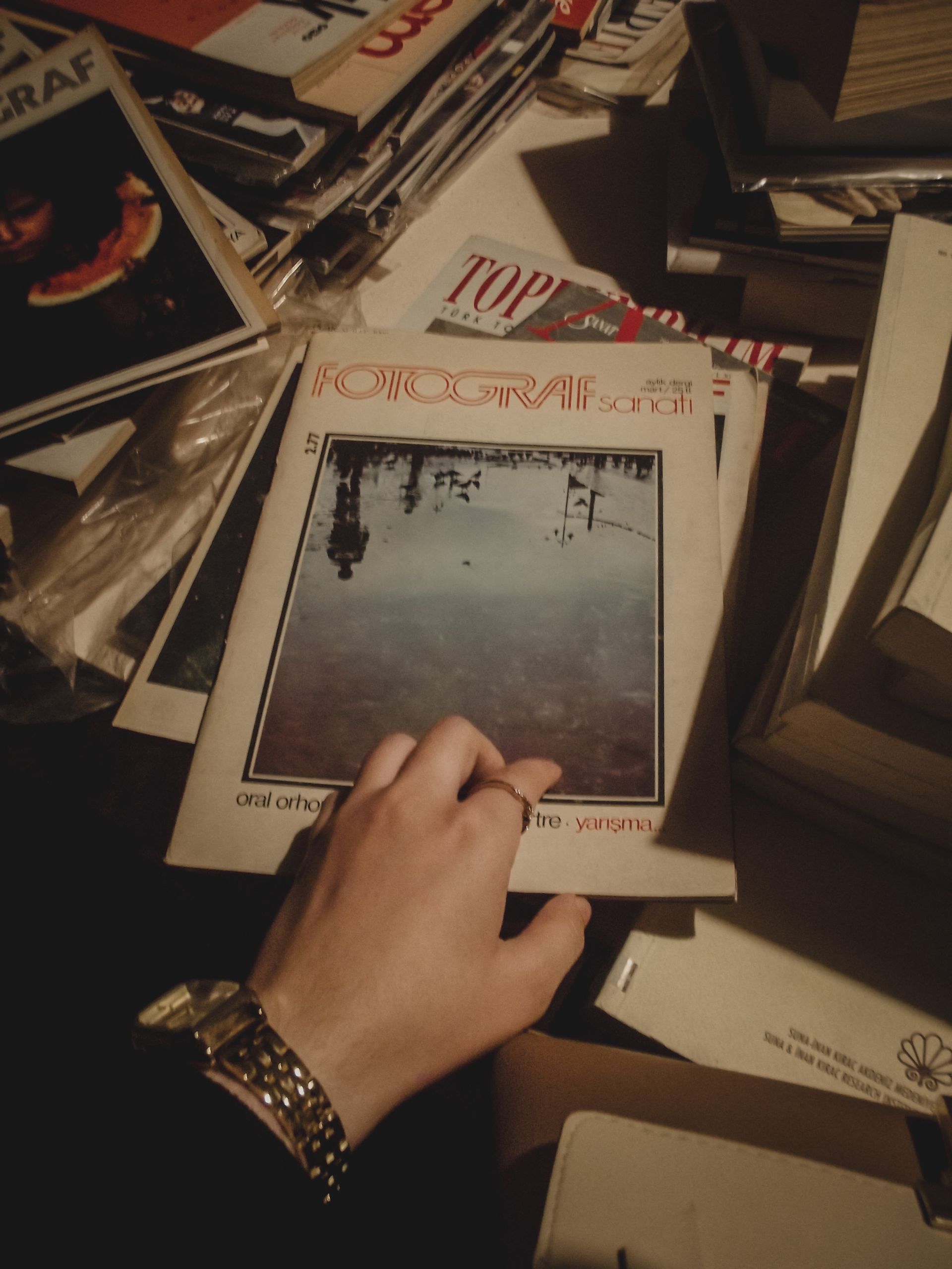 Person touching and reading a print magazine or zine — lo-fi counter-revolution frame for 