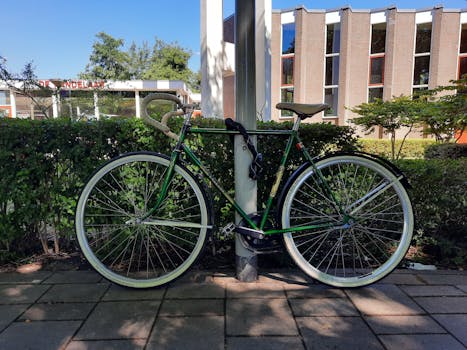 A classic bicycle parked against a post in Amsterdam, showcasing urban cycling culture.