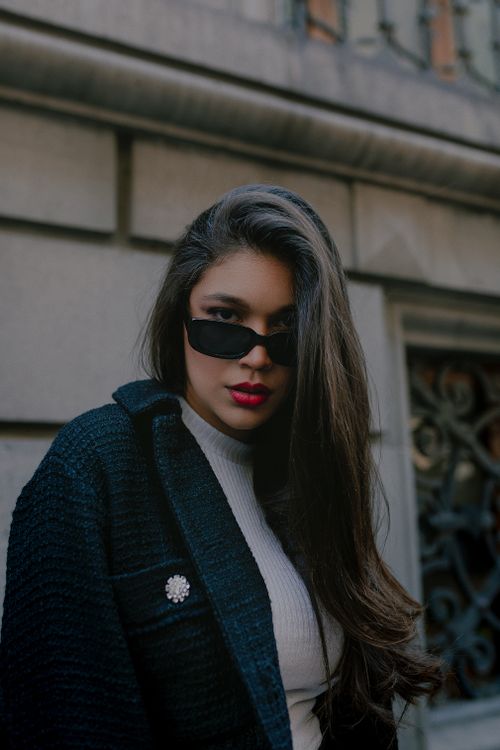 Free Portrait of a fashionable young woman in sunglasses posing confidently in the streets of Mexico City. Stock Photo