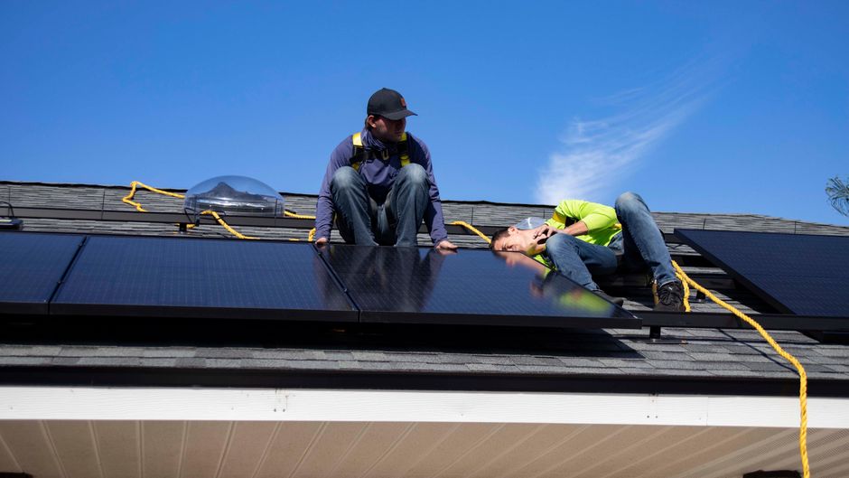 Professional installation team safely working on a roof in a US neighborhood - solar installers in ri Professional installation team safely working on a roof in a US neighborhood - solar installers in ri