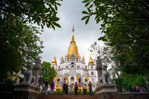 Free Stunning temple with golden spires set amidst lush gardens, popular with tourists. Stock Photo