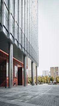 A vertical shot of a modern office building in Warsaw, Poland, showcasing sleek architecture and urban design.